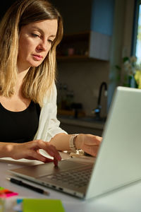 Young woman using laptop at table