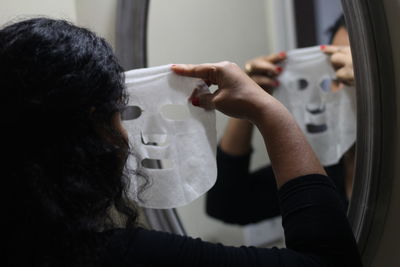 Woman using facial mask at home