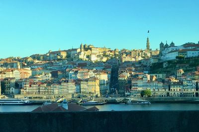 Buildings in city against clear blue sky