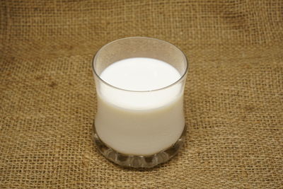 Close-up of milk in glass on jute