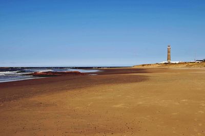 Calm sea against clear blue sky