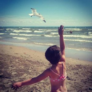 Rear view of a girl sitting on beach