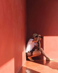 Rear view of woman sitting on wall