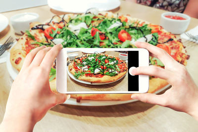 Midsection of man photographing food on table