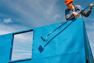 Low angle view of man standing on wall