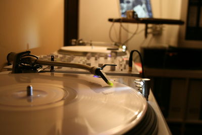 Close-up of record player needle in illuminated room