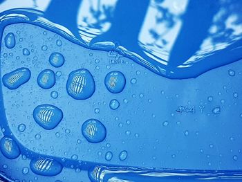 Close-up of raindrops on blue water