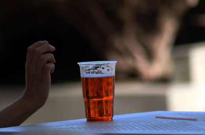 Midsection of woman drinking glass on table