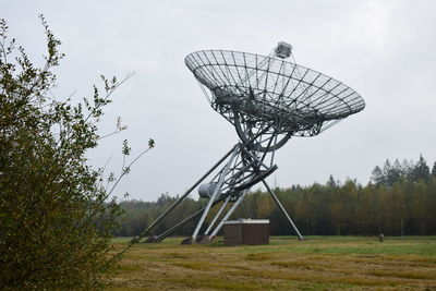 Low angle view of radio telescope on field against sky