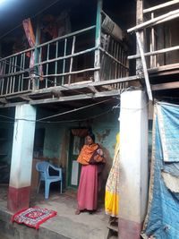 Portrait of woman standing against building