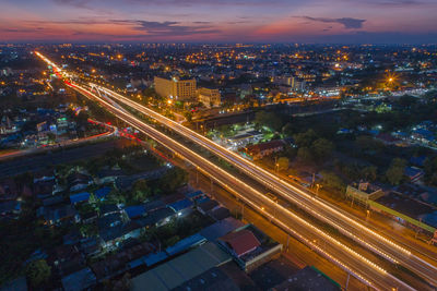 High angle view of illuminated city street and buildings at night