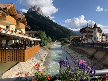 Scenic view of buildings by mountains against sky