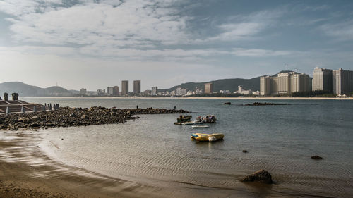 View of sea and buildings against sky