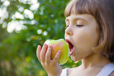 Close-up of young woman eating fruit