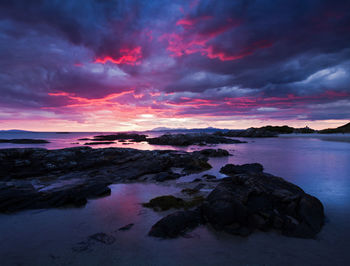 Scenic view of sea against dramatic sky during sunset