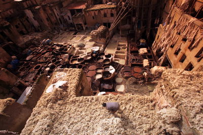 High angle view of people dyeing fabrics in containers