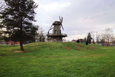 Traditional windmill on field against sky