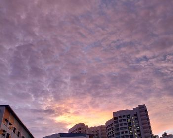 Low angle view of buildings against cloudy sky