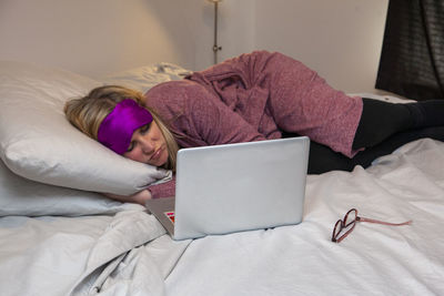 Woman lying down on bed at home