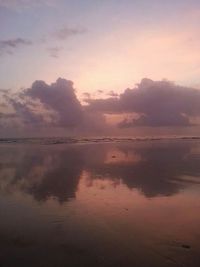 Reflection of clouds in sea at sunset