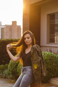 Portrait of young woman leaning against fire hydrant 