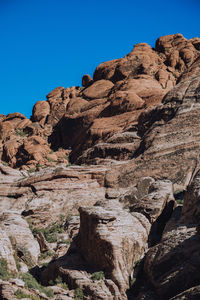 Low angle view of rock formation against clear blue sky