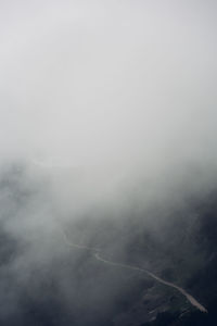Scenic view of mountains in foggy weather against sky