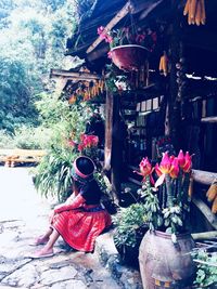 People sitting by potted plant against building