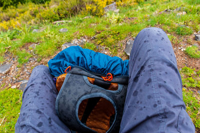 A first-person pov shot of a hiker sitting with a backpack while it's raining in the french alps