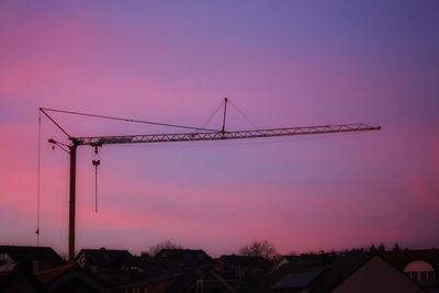 Low angle view of crane against sky during sunset