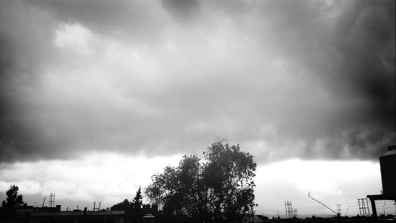 sky, low angle view, cloud - sky, cloudy, tree, silhouette, weather, overcast, storm cloud, cloud, nature, built structure, beauty in nature, dusk, building exterior, high section, architecture, tranquility, dramatic sky, cloudscape