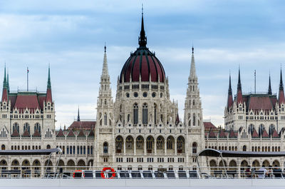 Buildings in city against cloudy sky