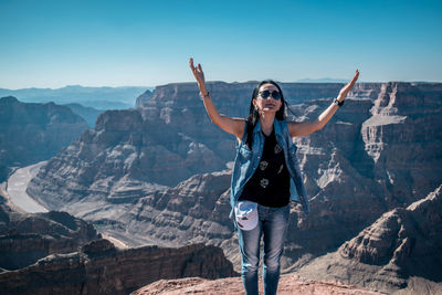 Full length of young woman standing on mountain