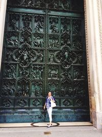 Full length of woman standing against building