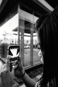 Portrait of woman photographing through smart phone