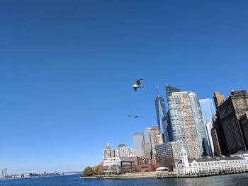 City at waterfront against blue sky
