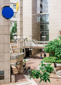 People walking on street by building in city