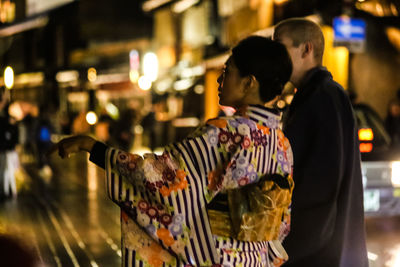 People in illuminated city at night