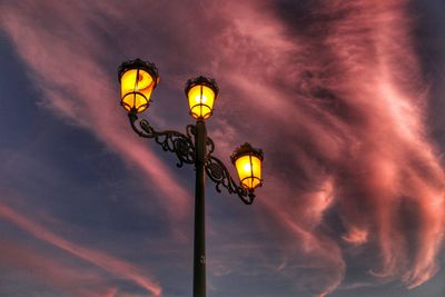 Low angle view of illuminated street light against sky