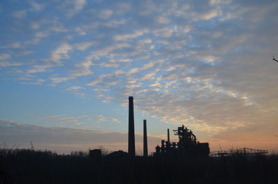 Factory against sky during sunset