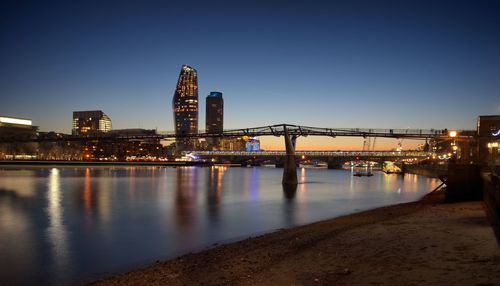 Bridge over river in city at night