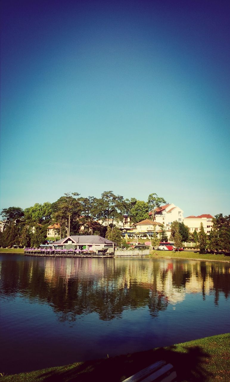 architecture, built structure, building exterior, clear sky, water, blue, copy space, reflection, tree, house, lake, waterfront, residential structure, river, residential building, outdoors, day, tranquility, town, sky