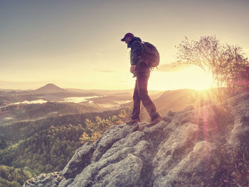 Moment of loneliness. man on the rock empires and watch over the misty landscape