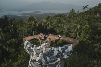 Midsection of man against trees on mountain