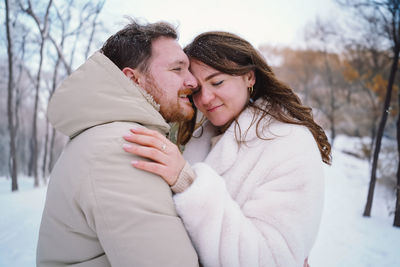 Loving couple on a snowy winter field. happy together.