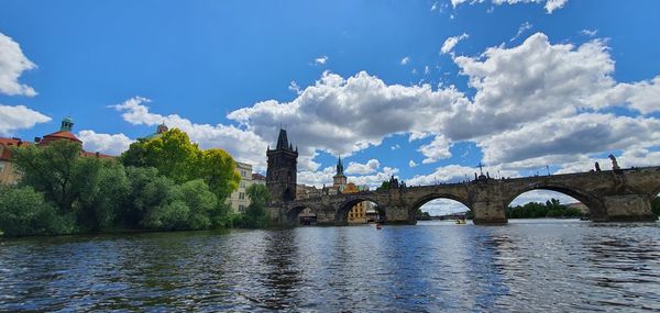 Arch bridge over river against sky