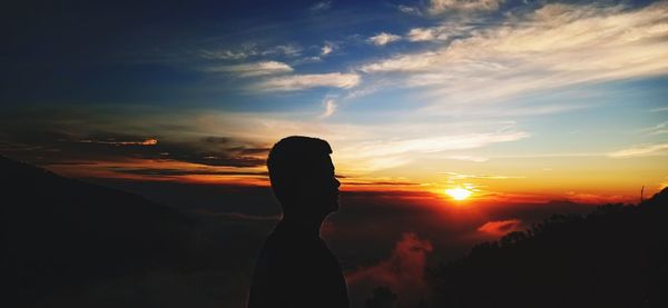 Silhouette man standing against sky during sunset