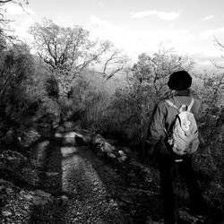 Rear view of woman standing by tree