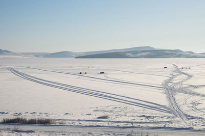 Snow covered landscape against clear sky