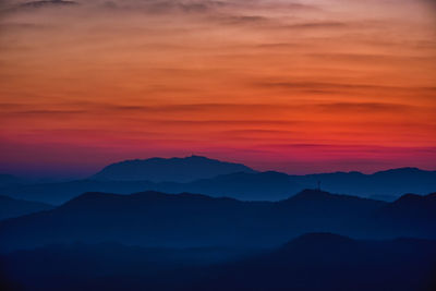 Scenic view of silhouette mountains against romantic sky at sunset